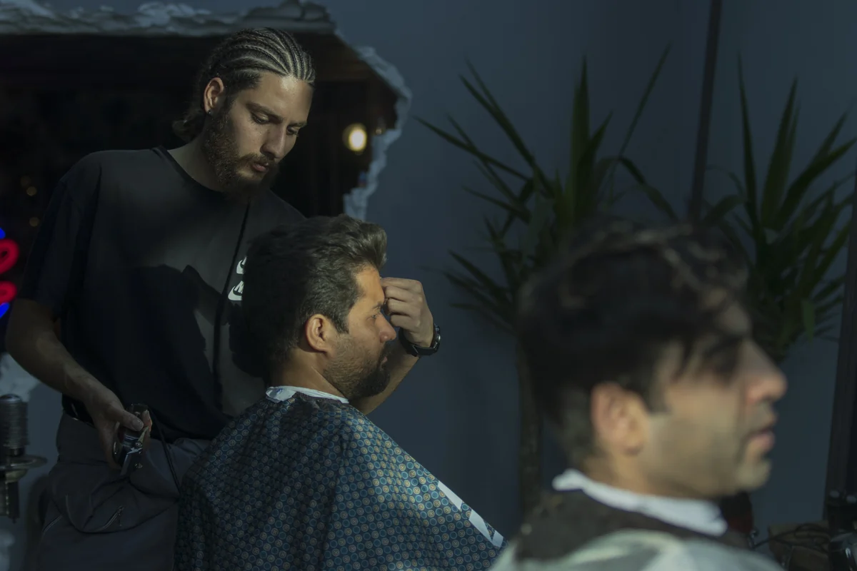 Barber styling a client in a salon